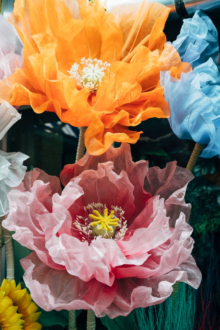 Vibrant artificial flowers in vivid colors create a striking decorative display.