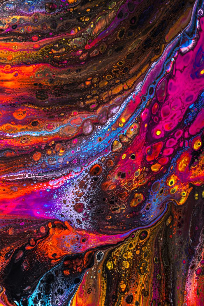 Abstract background of bright painting with colorful fluid acrylic paints creating stains and splatters on creative artwork with multicolored pigments